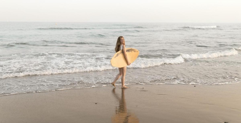 surfer met surfboard op het strand